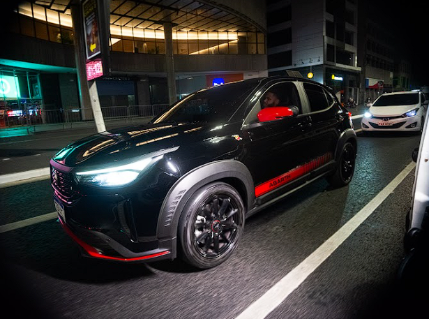 Kabatistta em carro preto atravessando a cidade à noite